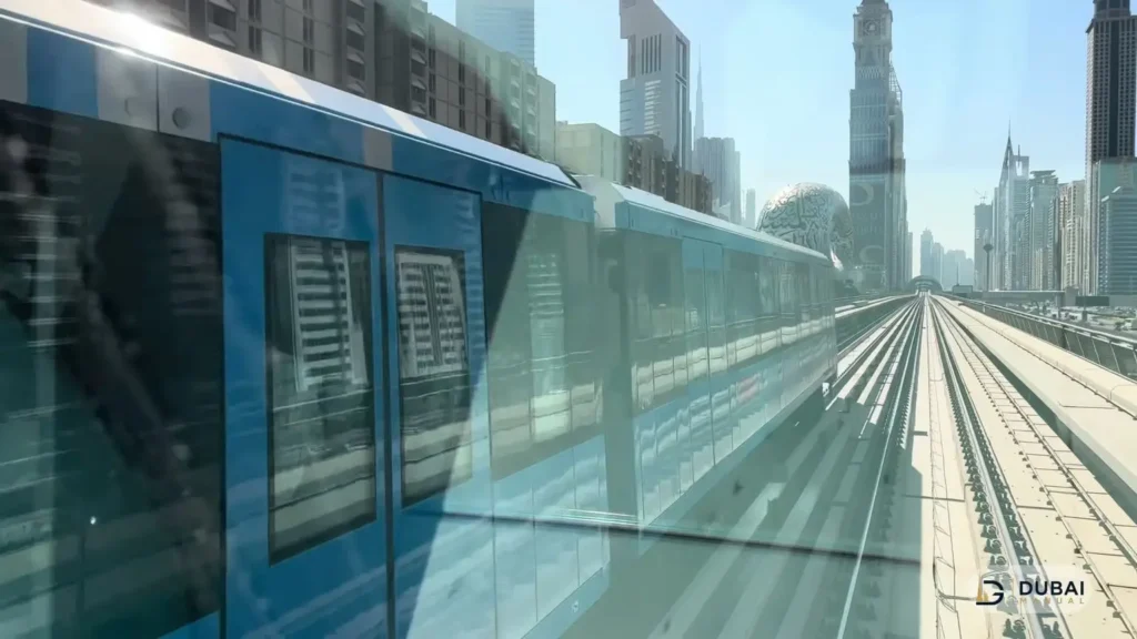 Blue Dubai Metro train passing alongside tracks near Museum of the Future