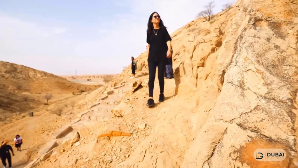 Hiker climbing Fossil Rock in Sharjah's Central Region