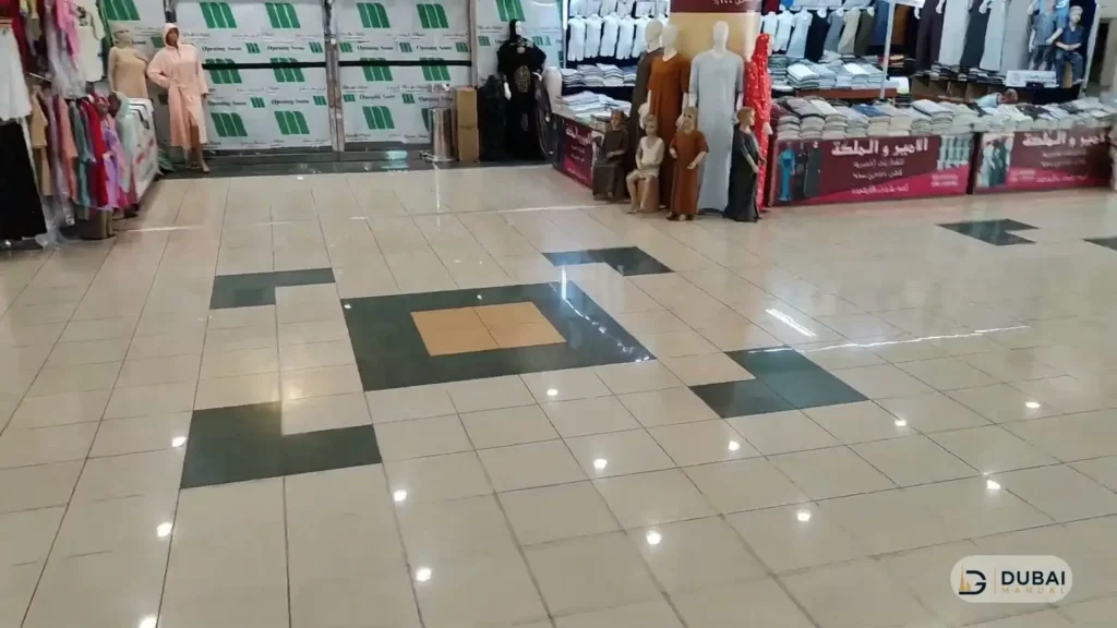 Market hall interior with clothing stalls at Al Mulla Plaza