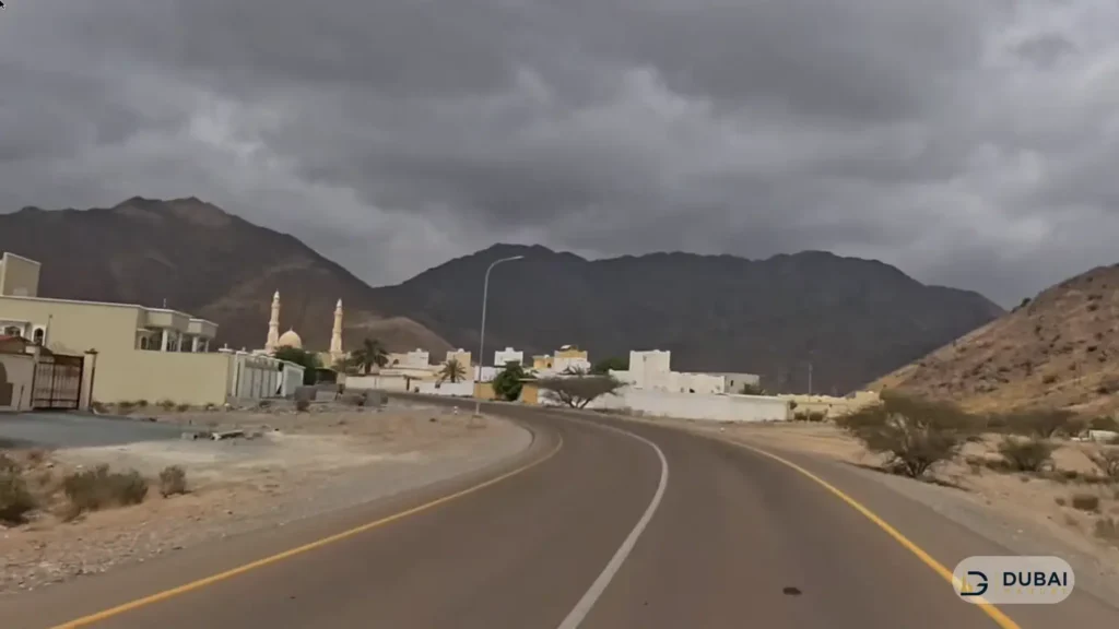 Mountain road leading to Nahwa enclave with village and mosque