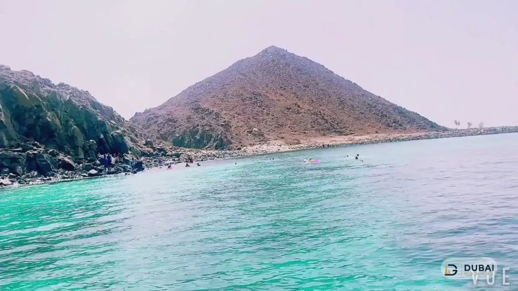 Snorkellers swimming in turquoise water by Sira Khorfakkan island
