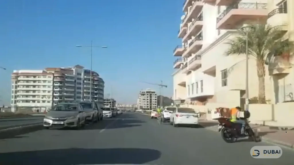 Street lined with apartment blocks in International City Phase 2